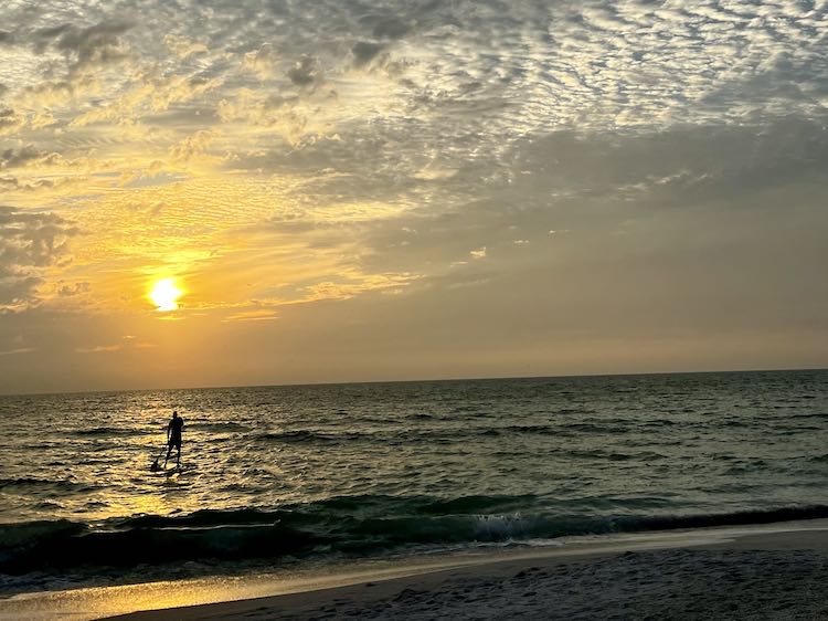 Person on SUP heading into an Anna Maria Island FL sunset